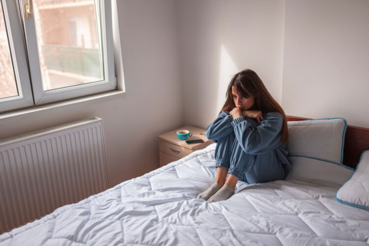 Depressed woman sitting in bed